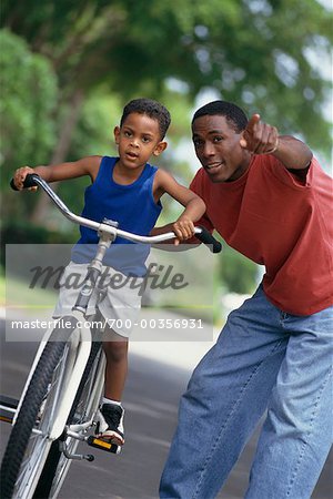 Father Helping Son Ride Bike