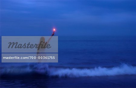 Woman Standing in Water Holding Flare