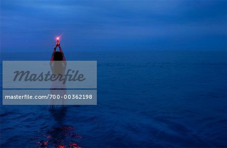 Woman Standing in Water at Night, Holding Light