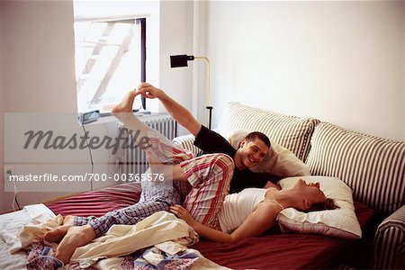 Man Tickling Woman in Bed