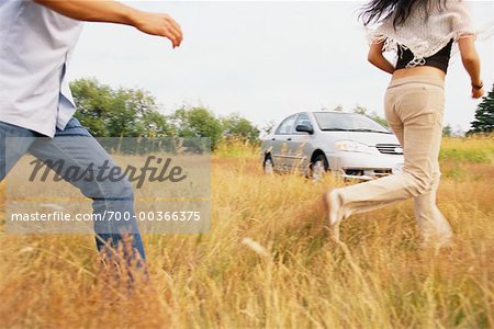 Couple en cours d'exécution à travers champ