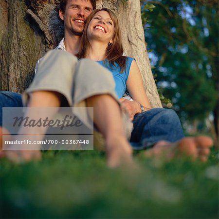 Paar unter Baum sitzt