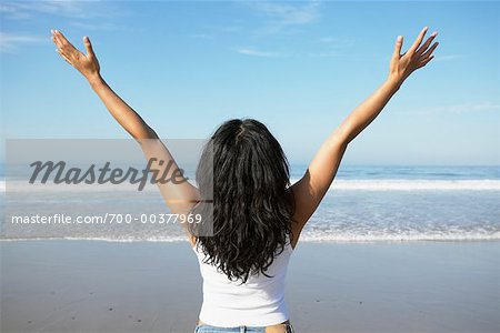 Woman on Beach with Arms in Air