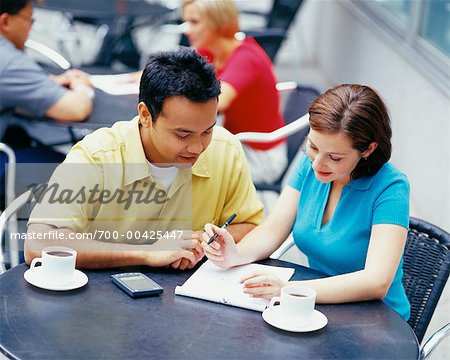Man and Woman with Notebook in Cafe