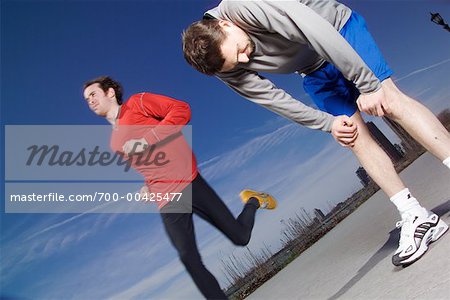 Man Resting While Other Man is Jogging