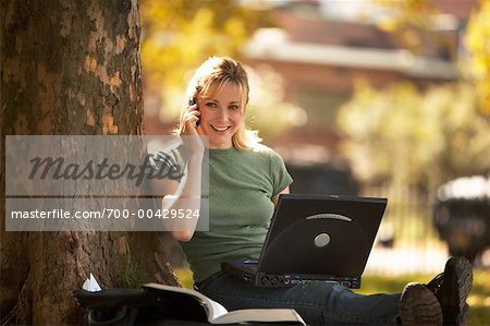 Frau mit Laptop und Handy im freien