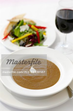 Pilzsuppe mit Wein und Salat serviert