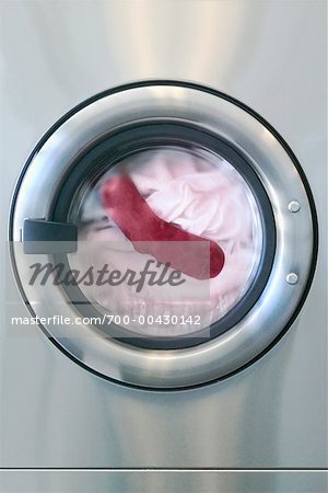 Rote Socke mit weißen Kleidung In der Waschmaschine