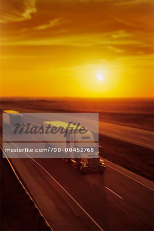 Camions de transport sur route au coucher du soleil
