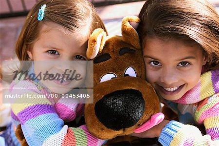 Zwei kleine Mädchen umarmt Stofftier