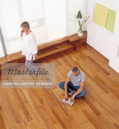 Man Using Laptop Computer and Woman On Telephone