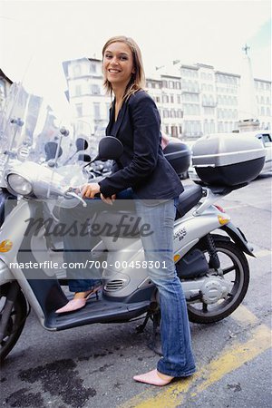 Frau sitzt auf Moped