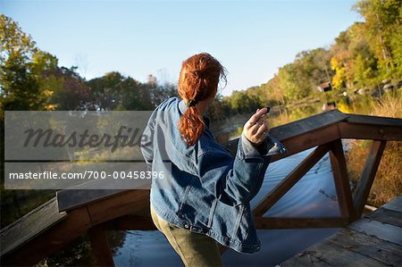 Woman Skipping Rocks from Bridge