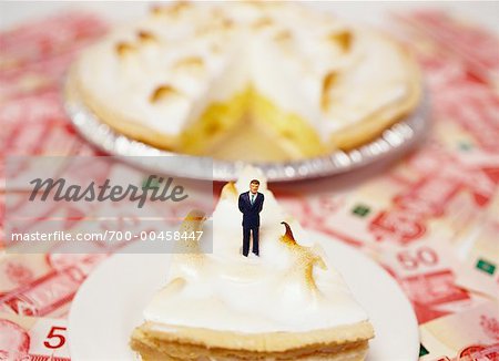 Toy Businessman on Piece of Pie, Canadian Currency in Background