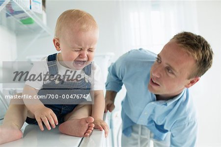 Father in Laundry Room with Crying Baby