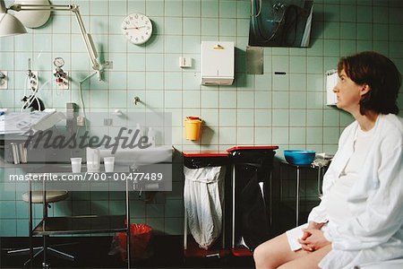 Femme enceinte, en regardant l'horloge dans la salle d'hôpital
