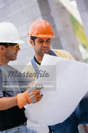 Deux travailleurs de la Construction en regardant des Plans
