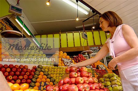 Femme devant un Stand de fruits