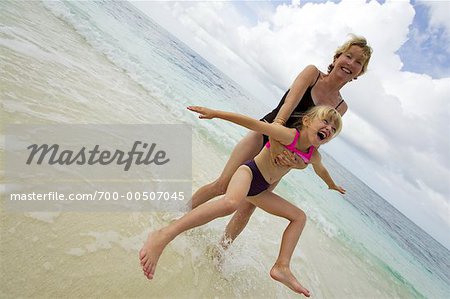 Mother Swinging Daughter on Beach Maldives, Indian Ocean