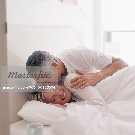 Man Kissing Woman in Bed