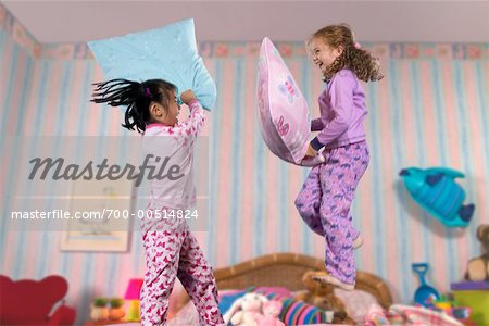 Deux jeunes filles ayant une bataille d'oreillers