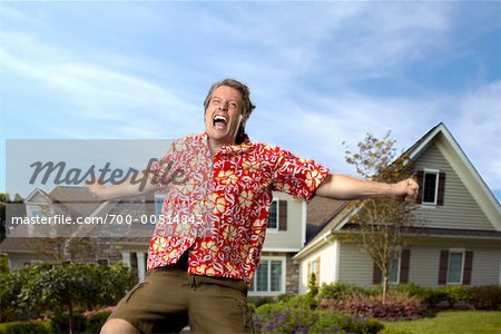 Man Cheering In Front of Houses