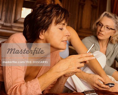 Femmes sur lit jouant avec les téléphones portables
