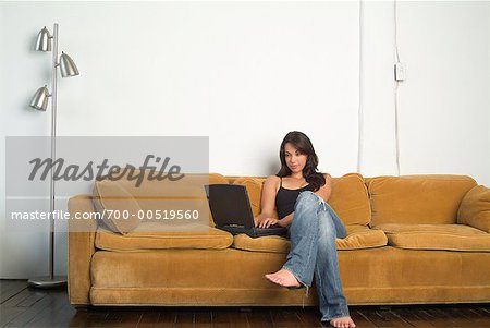 Femme sur le canapé, en utilisant un ordinateur portable