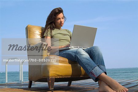 Frau am Dock mit Laptop und Stuhl