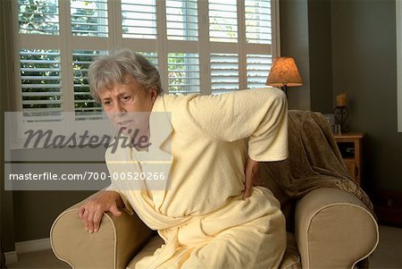 Femme avec des maux de dos de chaise