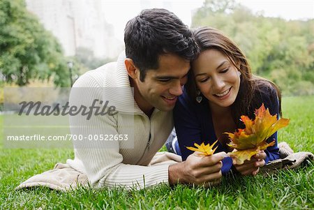 Couple Lying on Grass Looking at Leaves