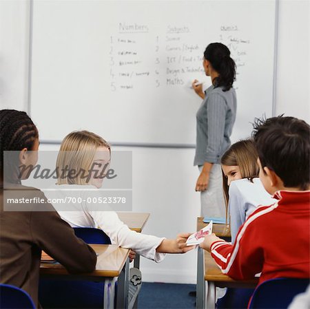 Students Passing A Note in the Classroom
