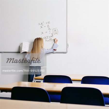 Étudiant par écrit sur le tableau blanc dans la salle de classe