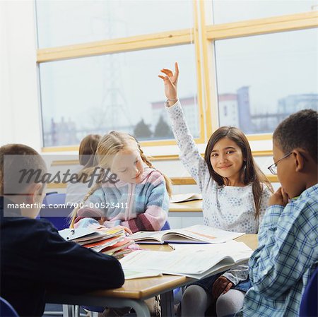 Main élever la jeune fille dans la salle de classe
