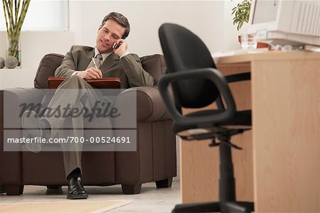 Businessman Using Cell Phone in Office