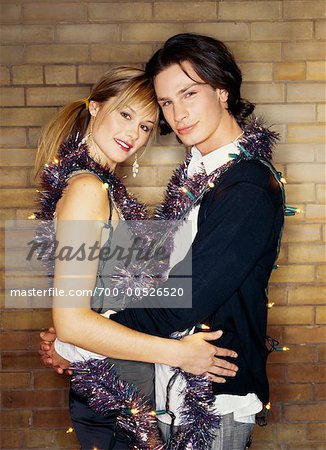 Couple Wrapped in String of Lights and Garland