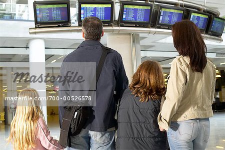 Famille regarder des données de vol dans l'aéroport