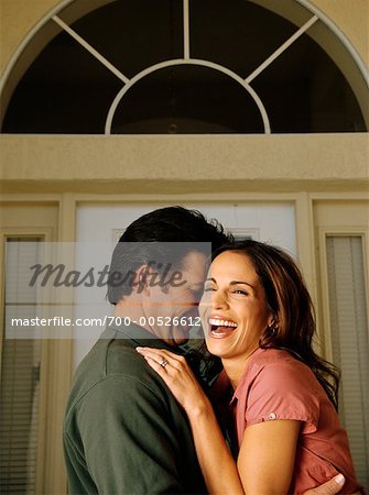 Couple s'enlaçant par la porte d'entrée