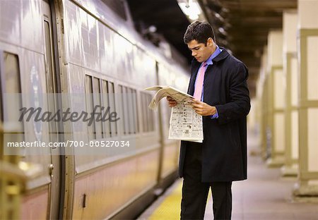 Man Reading Newspaper in Subway Station, New York, USA
