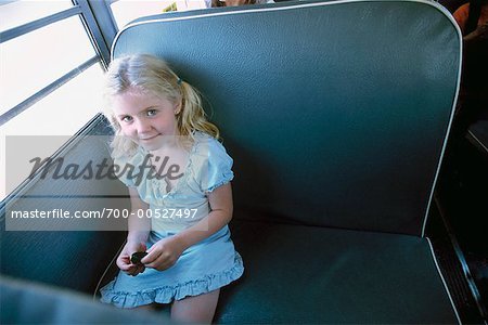 Fille assise sur les autobus scolaires