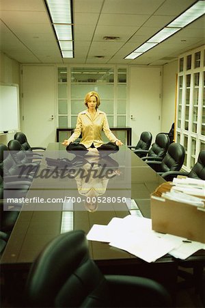 Woman Meditating in Boardroom