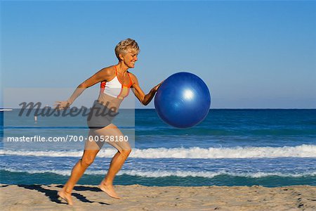 Femme avec ballon d'exercice sur la plage