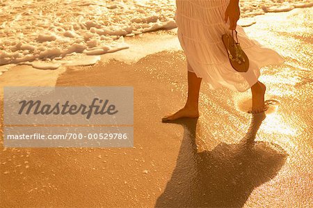 Femme qui marche le long de la plage