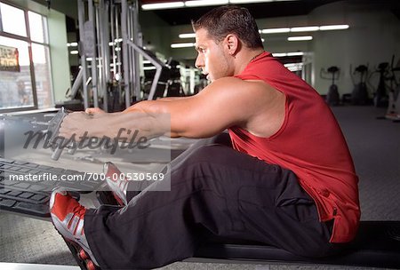 Homme à l'aide de poids Machine dans une salle de sport