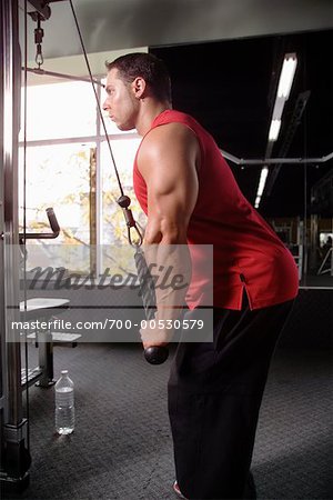 Homme à l'aide de poids Machine dans une salle de sport