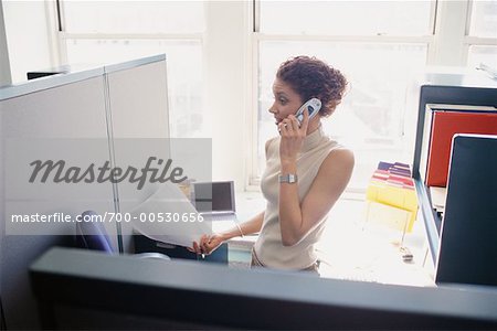 Femme au bureau avec un téléphone cellulaire et Document