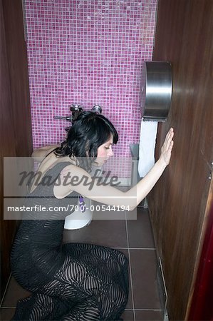 Femme assise sur le plancher de salle de bains