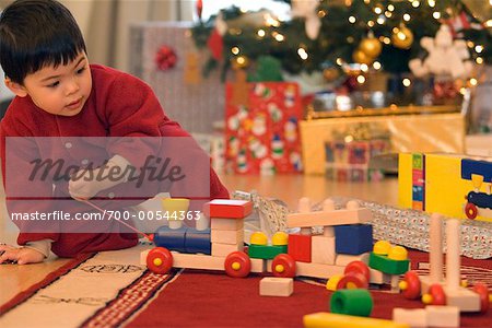 Jungen spielen mit Spielzeugeisenbahn am Weihnachtsmorgen