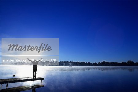 Silhouette de l'homme sur le quai au lever du soleil, le lac Little, Peterborough