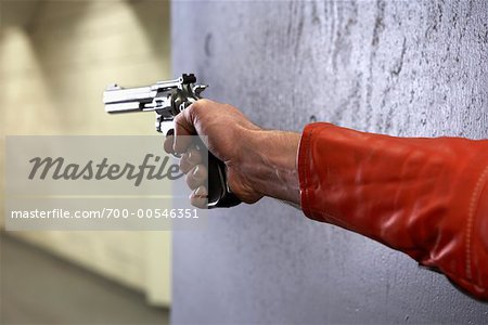 Man's Hand Holding Handgun and Aiming at Target